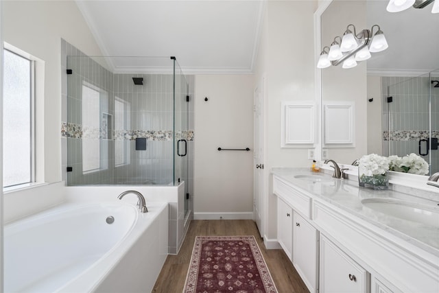 bathroom featuring a garden tub, crown molding, a sink, and a stall shower