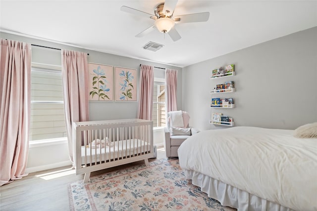 bedroom featuring wood finished floors, visible vents, and ceiling fan