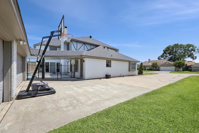 310 Yorkshire Ln, Port Neches, TX 77651 - rear view of house with roof with shingles, central air condition unit, fence, brick siding, and a lawn