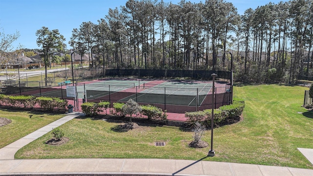 view of sport court with fence and a yard
