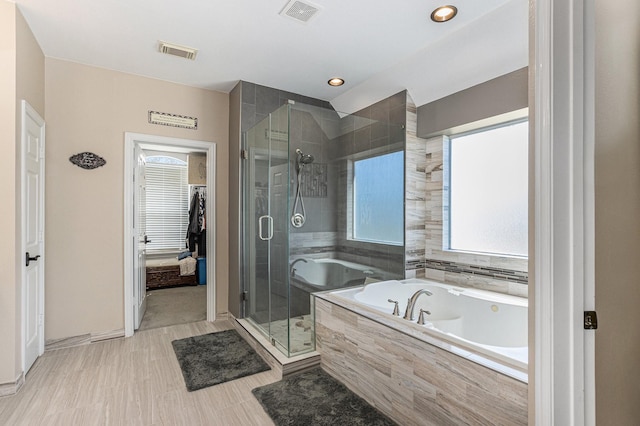 full bathroom featuring a wealth of natural light, visible vents, and a garden tub