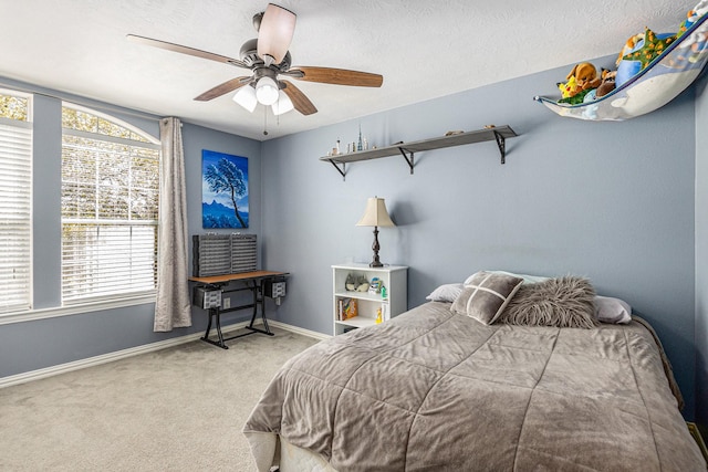 carpeted bedroom featuring multiple windows, baseboards, and ceiling fan