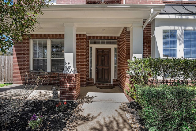 property entrance with brick siding and a porch