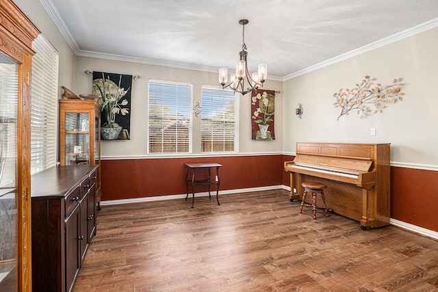 living area with wainscoting, an inviting chandelier, ornamental molding, and wood finished floors