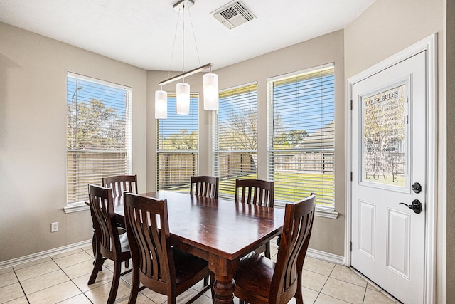 dining room featuring light tile patterned floors, baseboards, visible vents, and a wealth of natural light