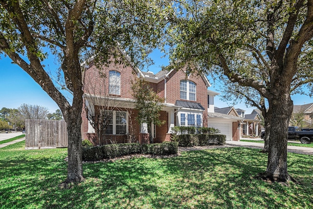 traditional-style home with an attached garage, driveway, a front lawn, and brick siding