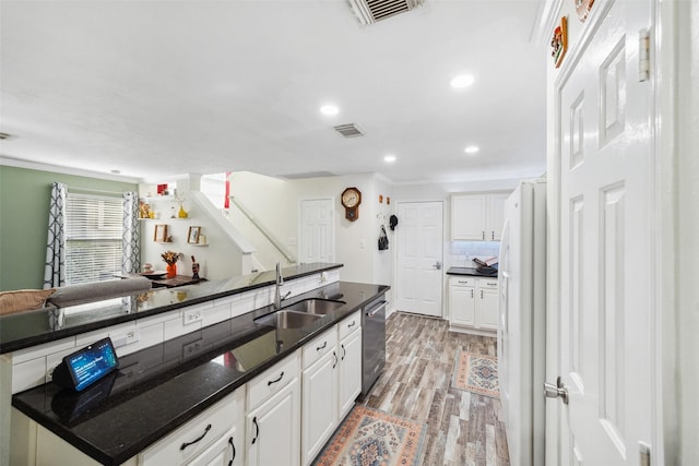 38 Wineberry Pl, The Woodlands, TX 77382 - kitchen with freestanding refrigerator, light wood-style flooring, dishwasher, a sink, and white cabinets