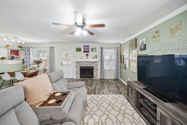 38 Wineberry Pl, The Woodlands, TX 77382 - living area with a ceiling fan, a stone fireplace, wood finished floors, ornamental molding, and plenty of natural light