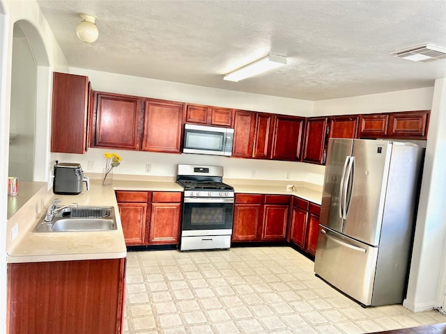 19334 Little Pine Ln, Katy, TX 77449 - kitchen featuring light countertops, dark brown cabinets, visible vents, a sink, and appliances with stainless steel finishes