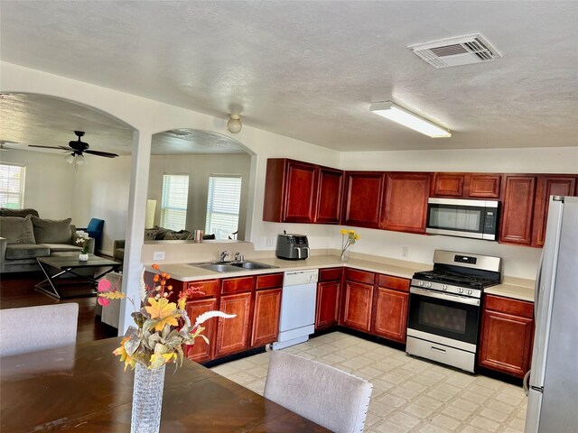 19334 Little Pine Ln, Katy, TX 77449 - kitchen featuring dark brown cabinets, visible vents, a sink, a wealth of natural light, and appliances with stainless steel finishes
