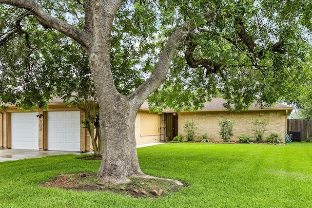 view of front of property featuring fence, concrete driveway, a front yard, and brick siding