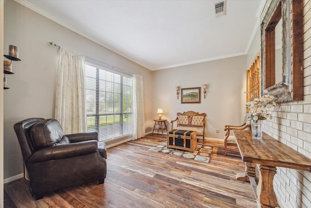 sitting room featuring visible vents, ornamental molding, baseboards, and wood finished floors