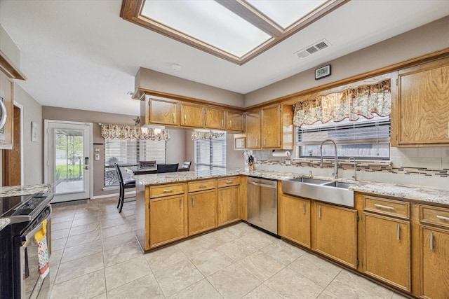 kitchen featuring visible vents, brown cabinetry, a peninsula, a sink, and stainless steel appliances