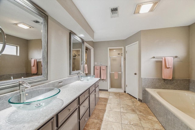 full bathroom with visible vents, a shower stall, a sink, and a garden tub