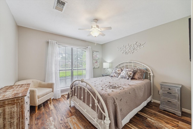 bedroom featuring visible vents, a ceiling fan, baseboards, and wood finished floors