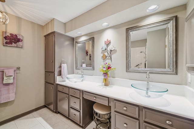 bathroom featuring double vanity, baseboards, a sink, and tile patterned flooring