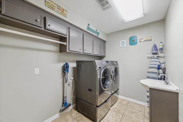 laundry area featuring independent washer and dryer, light tile patterned flooring, cabinet space, baseboards, and visible vents