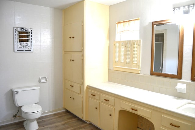 bathroom with toilet, backsplash, vanity, and wood finished floors