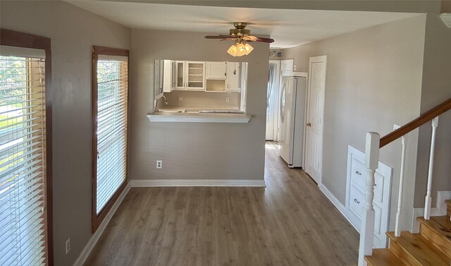 11 Ridgeway St, Coldspring, TX 77331 - kitchen featuring baseboards, freestanding refrigerator, white cabinetry, wood finished floors, and ceiling fan