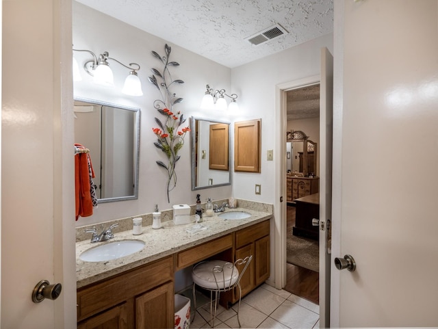 1814 Cliffdale Dr, Missouri City, TX 77489 - bathroom featuring tile patterned floors, visible vents, a sink, and a textured ceiling