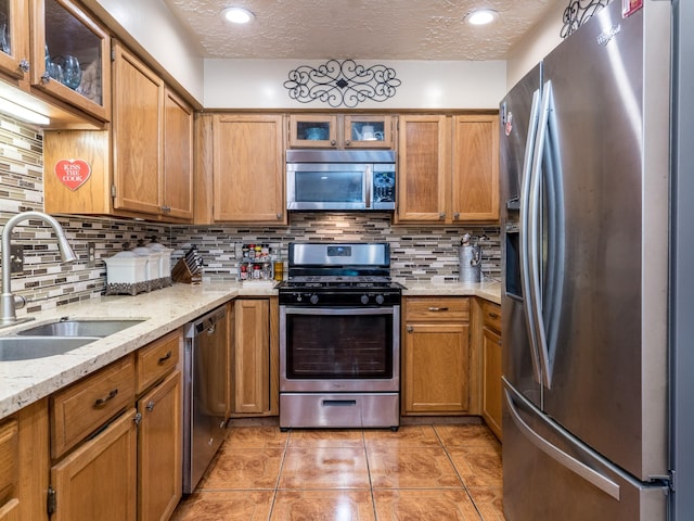 1814 Cliffdale Dr, Missouri City, TX 77489 - kitchen with appliances with stainless steel finishes, tasteful backsplash, a sink, and a textured ceiling