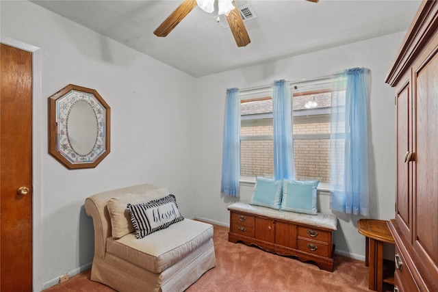 living area featuring visible vents, a ceiling fan, baseboards, and light carpet