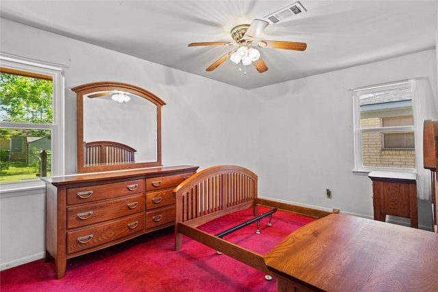 bedroom with dark carpet, baseboards, a ceiling fan, and visible vents