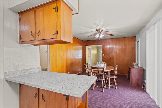 kitchen with a ceiling fan, brown cabinetry, light countertops, a peninsula, and visible vents