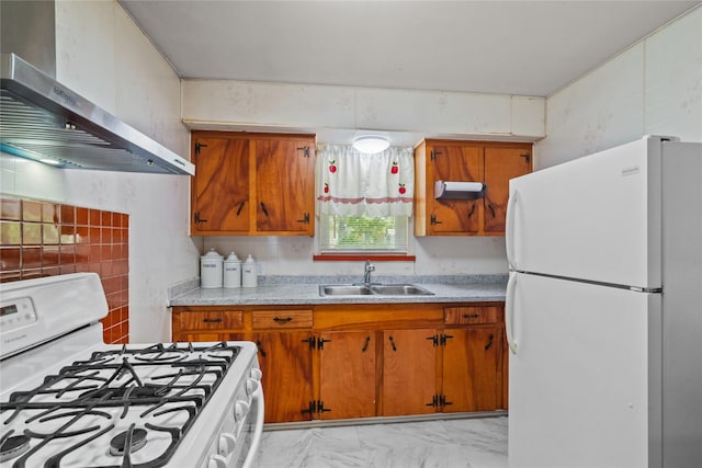 kitchen featuring brown cabinets, light countertops, wall chimney range hood, a sink, and white appliances