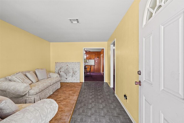 living room featuring baseboards and visible vents