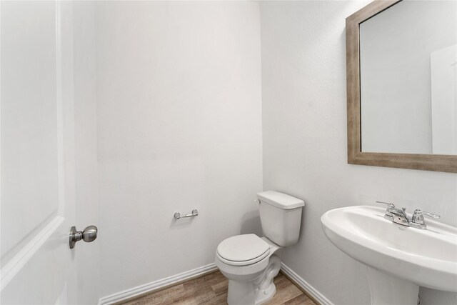 546 Long Beach Bay Dr, Katy, TX 77493 - half bathroom with baseboards, toilet, wood finished floors, and a sink