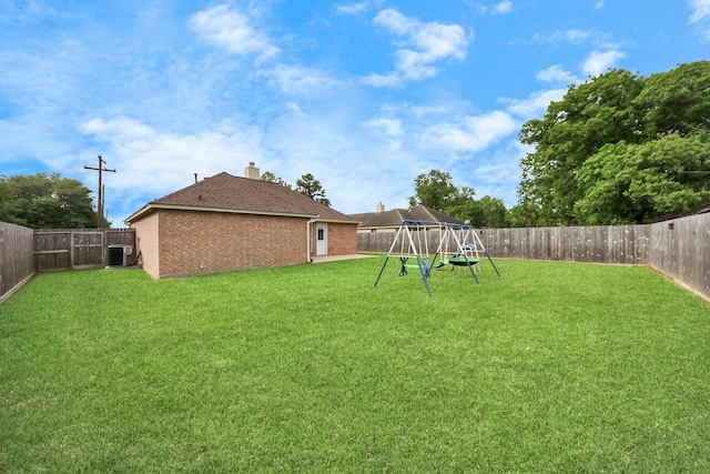 3011 Fairchild Ave, Needville, TX 77461 - view of yard with a fenced backyard, central AC, and a playground