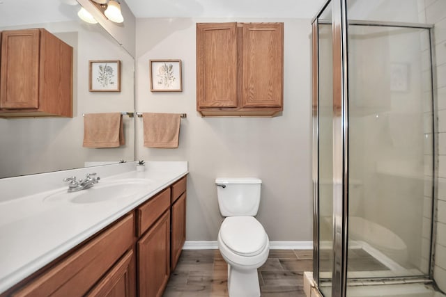 3011 Fairchild Ave, Needville, TX 77461 - full bathroom with wood finished floors, toilet, vanity, baseboards, and a stall shower