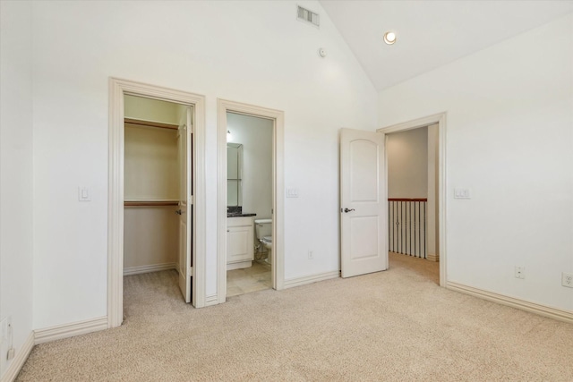 91 Sidney St, Houston, TX 77003 - unfurnished bedroom featuring a walk in closet, baseboards, visible vents, and light colored carpet