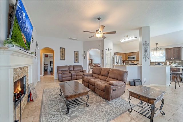 606 Sea Anchor Way, Crosby, TX 77532 - living area with light tile patterned floors, arched walkways, a ceiling fan, and a fireplace