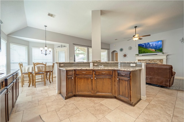 606 Sea Anchor Way, Crosby, TX 77532 - kitchen featuring light stone counters, pendant lighting, visible vents, open floor plan, and ceiling fan with notable chandelier