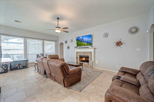 606 Sea Anchor Way, Crosby, TX 77532 - living area with visible vents, a ceiling fan, arched walkways, baseboards, and a fireplace