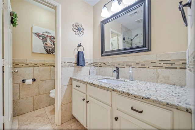 606 Sea Anchor Way, Crosby, TX 77532 - bathroom with a wainscoted wall, toilet, tile walls, tile patterned flooring, and vanity