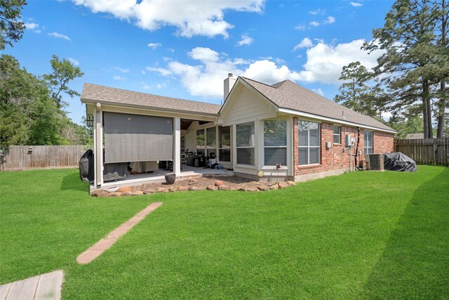 606 Sea Anchor Way, Crosby, TX 77532 - back of property featuring a chimney, a fenced backyard, cooling unit, a patio area, and a lawn