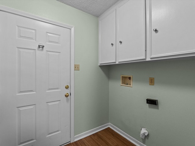 laundry room featuring washer hookup, a textured ceiling, cabinet space, baseboards, and dark wood-type flooring