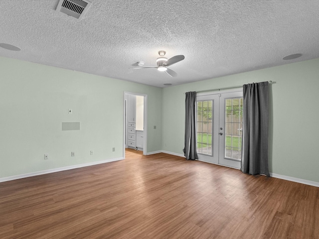 spare room featuring a ceiling fan, french doors, visible vents, wood finished floors, and baseboards