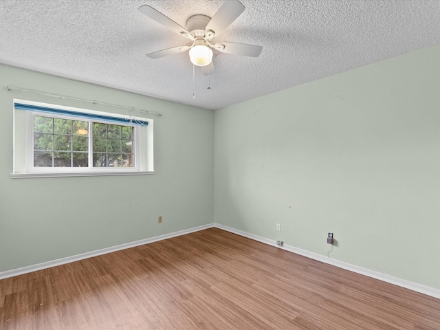 unfurnished room featuring baseboards, a textured ceiling, ceiling fan, and wood finished floors
