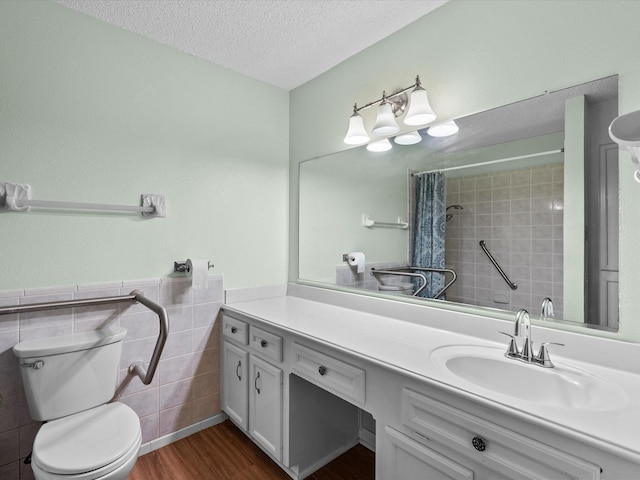 bathroom featuring a textured ceiling, tile walls, a tile shower, wood finished floors, and toilet