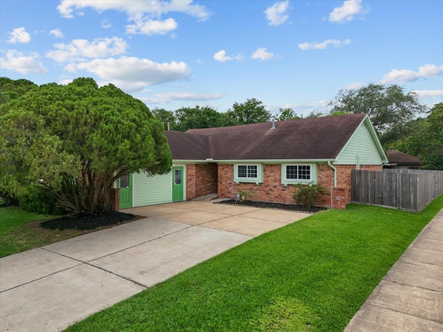 ranch-style house with brick siding, a front lawn, fence, and concrete driveway