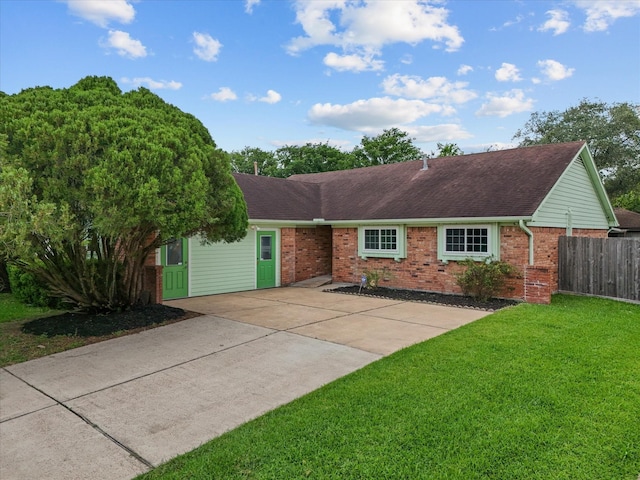 ranch-style home featuring brick siding, fence, roof with shingles, and a front lawn