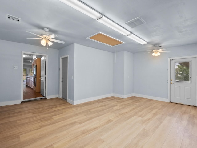 unfurnished room featuring visible vents, attic access, light wood finished floors, and ceiling fan