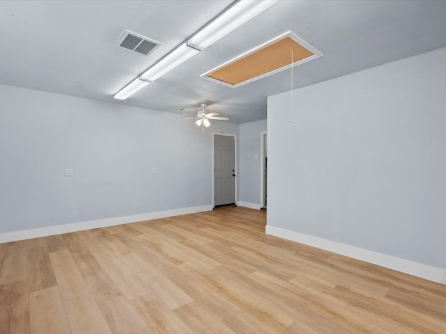 unfurnished room featuring baseboards, attic access, light wood-type flooring, and visible vents