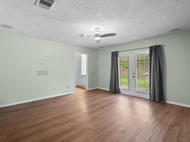 spare room with visible vents, wood finished floors, baseboards, french doors, and a ceiling fan