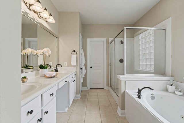13115 Parkbrook Way Ln, Sugar Land, TX 77498 - full bath featuring a garden tub, double vanity, a stall shower, tile patterned floors, and baseboards