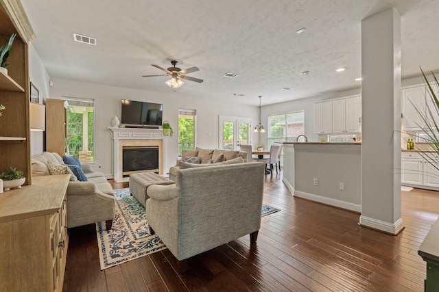 13115 Parkbrook Way Ln, Sugar Land, TX 77498 - living area featuring a ceiling fan, recessed lighting, a glass covered fireplace, dark wood-style flooring, and baseboards